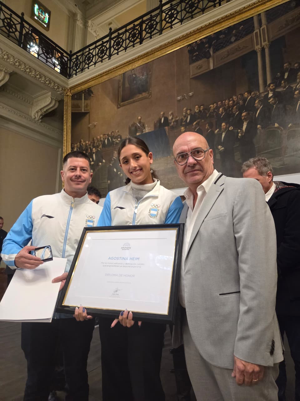 Agostina Hein junto a su entrenador Sebastián Montero y el presidente de la CADDA Sergio Antonini, tras recibir el Premio Islas Malvinas en el Congreso de la Nación
