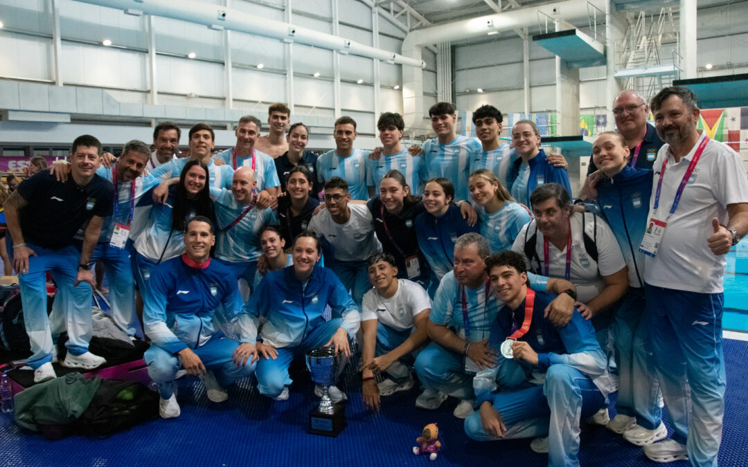Delegación argentina de natación posa con un trofeo en el Centro Acuático Provincial de Rosario, en los Juegos Suramericanos