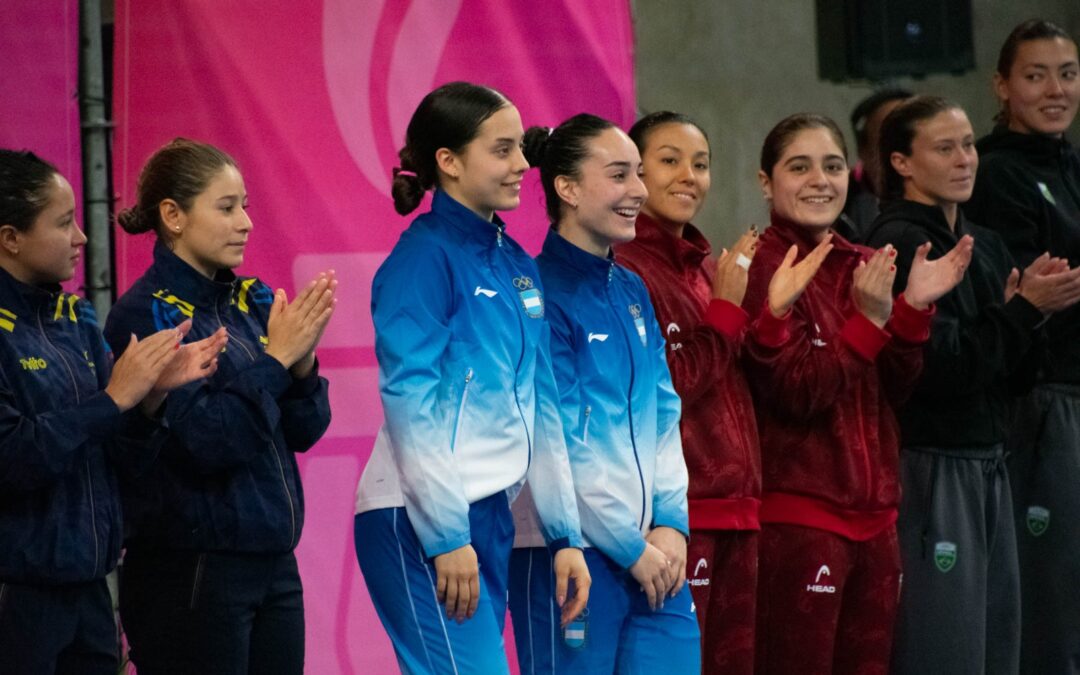 Azul Chiorazzo y Auka Sosa, de la selección argentina de clavados, sonríen junto a sus rivales en los Juegos Suramericanos